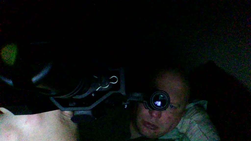 A man looking through the scope of his riffle